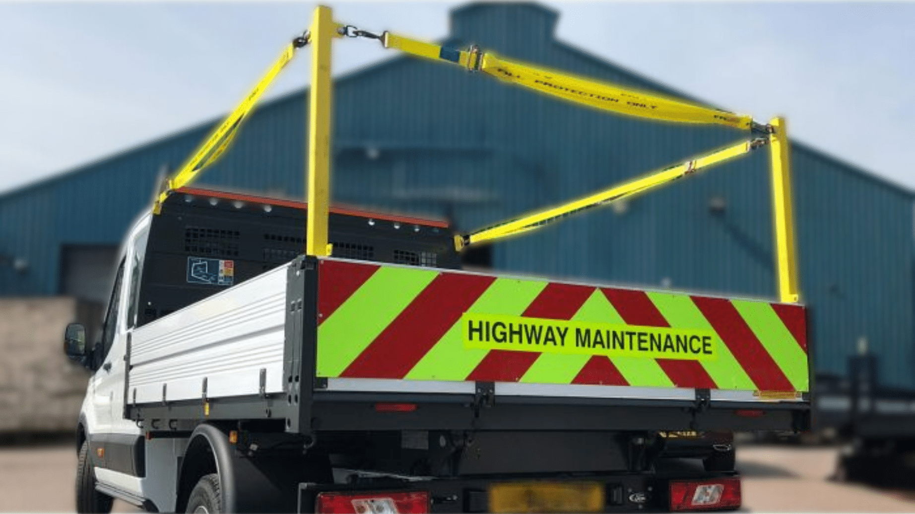 Fall arrest system with support pillars and strap installed on a commercial truck